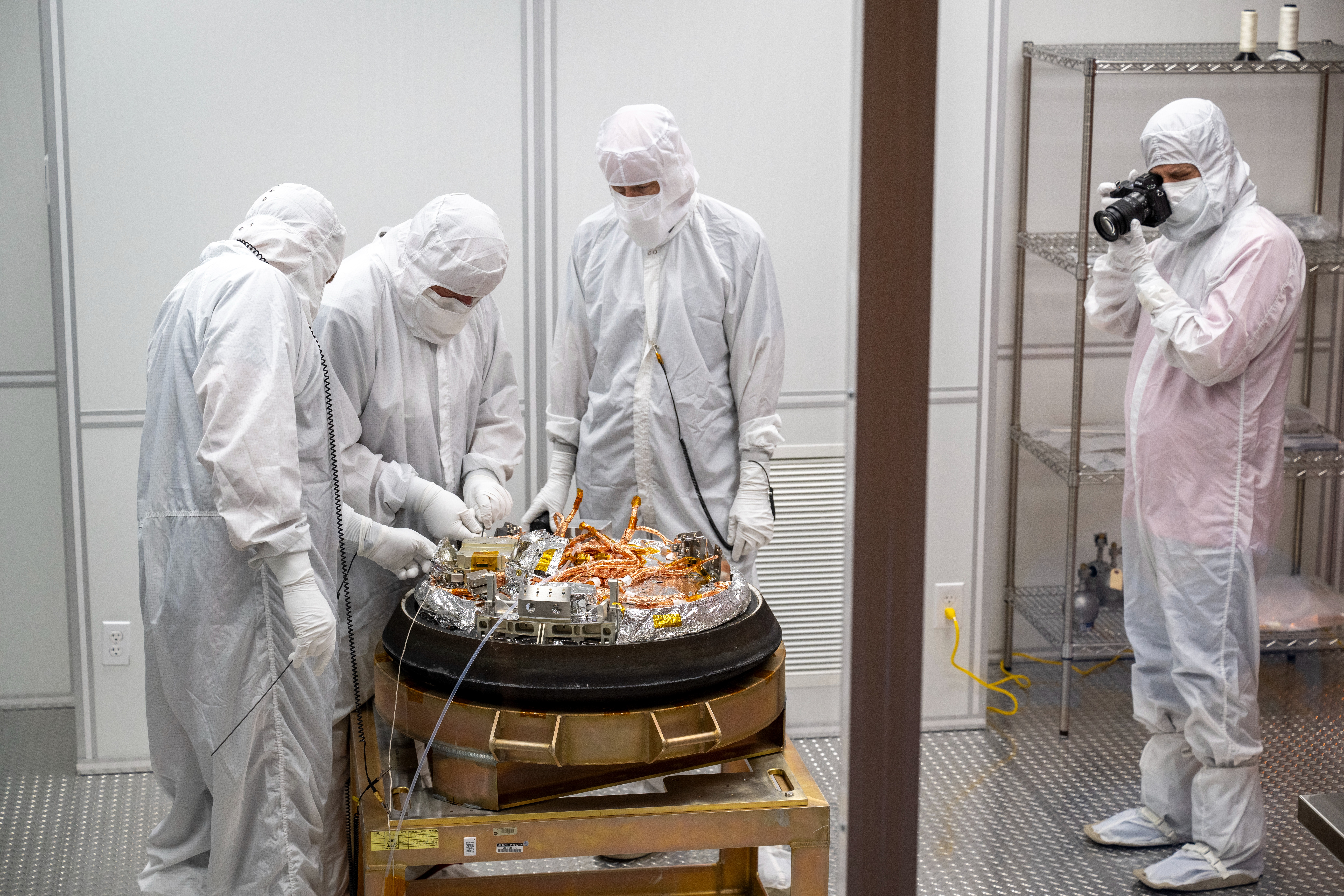 Curation crews process NASA's OSIRIS-REx mission sample return capsule in a clean room in 2023. Credit: NASA.