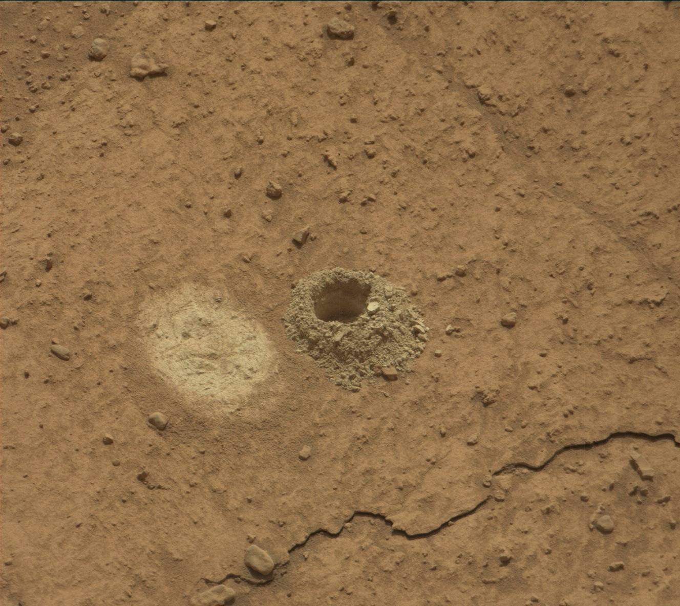 There are more than 40 holes on Mars. The drill aboard the Curiosity rover created the hole in a rock investigators call Mammoth Lakes. The bright spot to the left of the hole is where the rover smoothed a small area to collect spectroscopic data. Credit: NASA/JPL-Caltech/MSSS