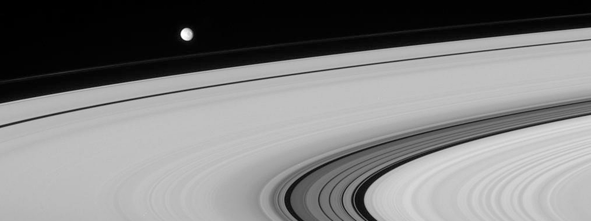 Saturn’s moon Mimas, floating above the planet’s rings, might conceal a liquid ocean beneath its surface.