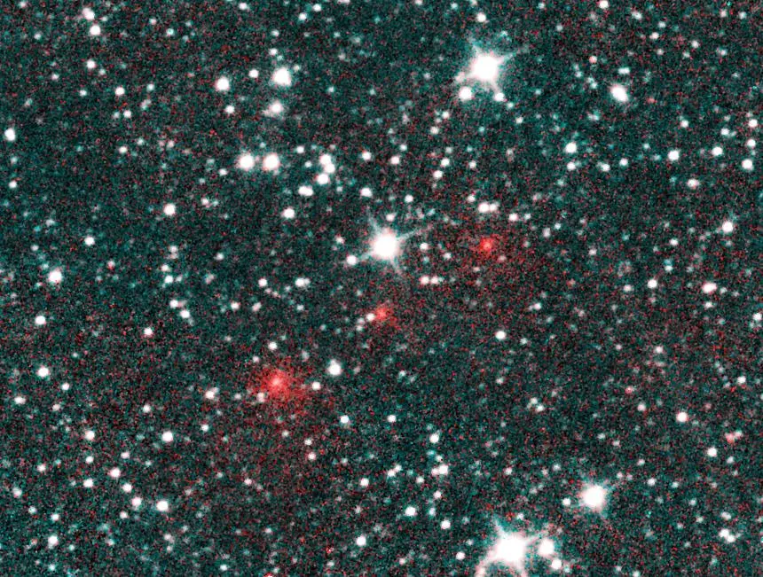 Comet C/2020 F3 NEOWISE appears as a string of fuzzy red dots in this composite of several heat-sensitive infrared images taken by NASA's NEOWISE space telescope on March 27, 2020.