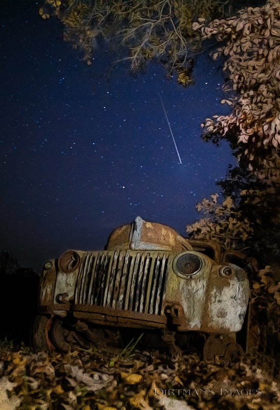 Leonid meteor in the sky with an old car in the foreground