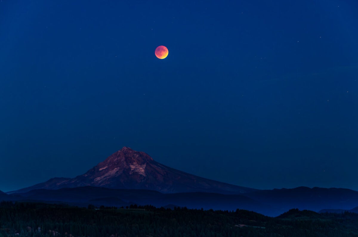 total lunar eclipse above a mountain